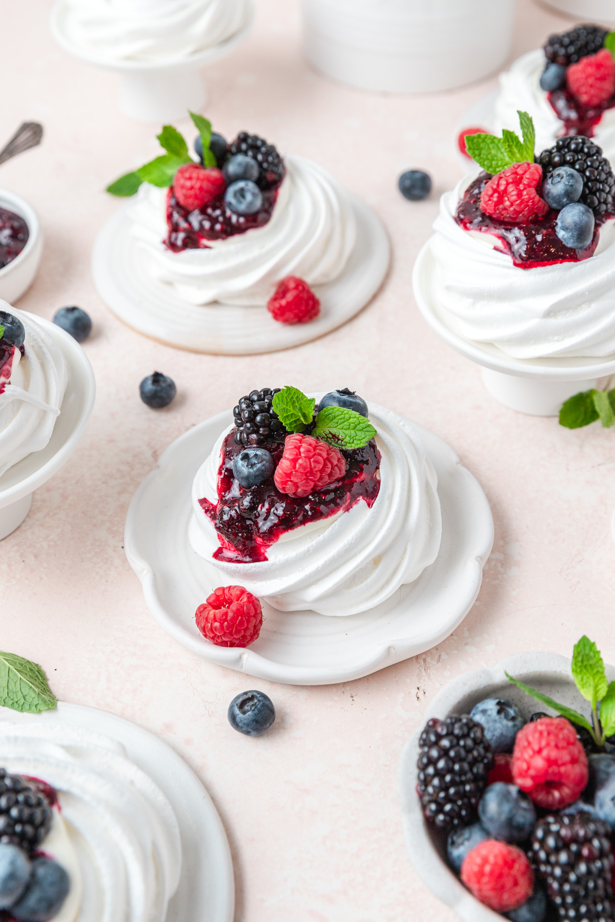 mini meringue nests with berries and whipped cream.