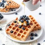 homemade sourdough discard waffles topped with blueberries and maple syrup.