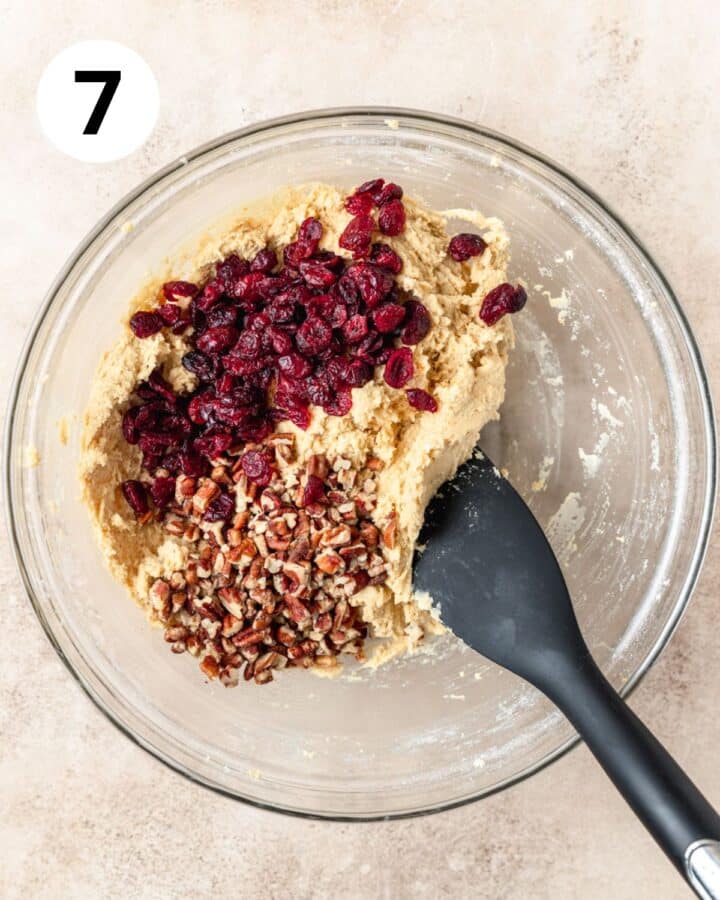 adding dried cranberries and pecans to dough. 