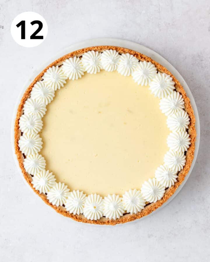 topping key lime cheesecake with whipped cream.