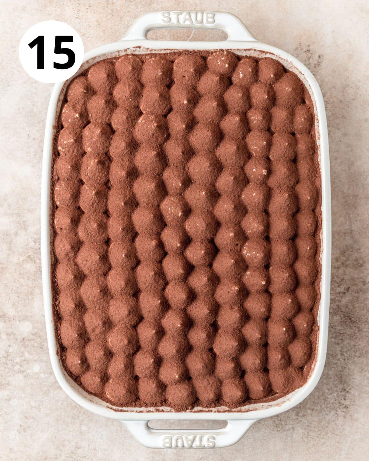 dusting tiramisu with cocoa powder.