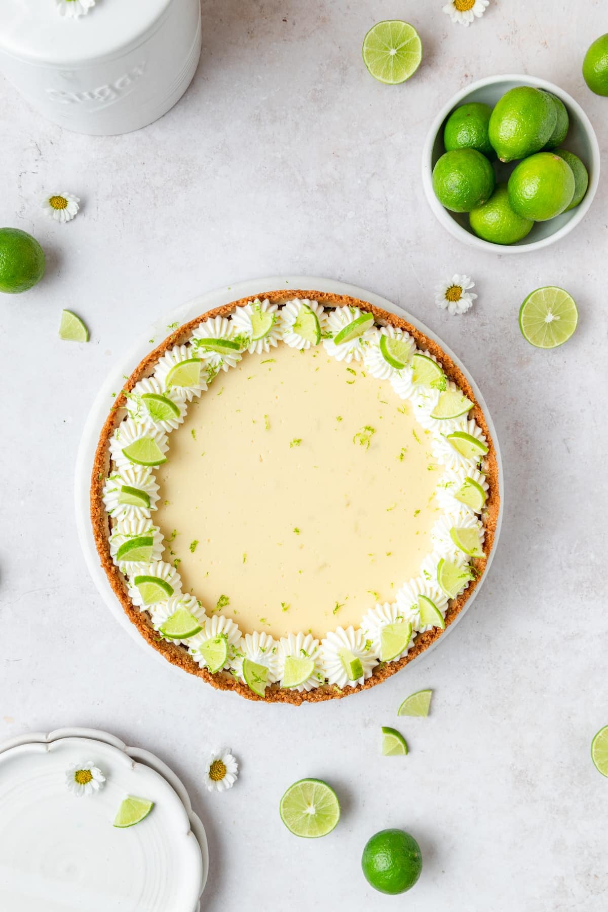 key lime cheesecake topped with whipped cream and key limes.