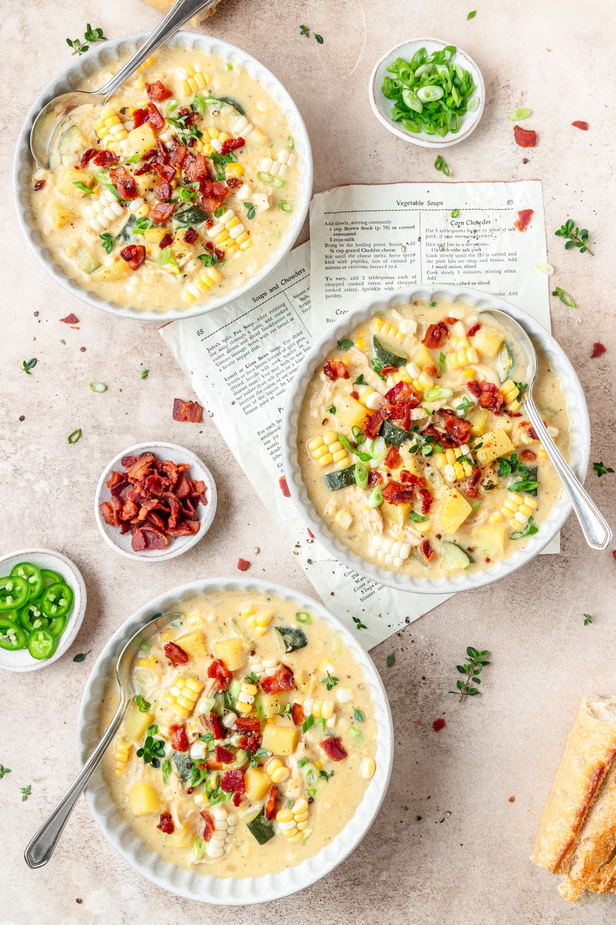 three bowls of creamy chicken corn chowder topped with bacon.