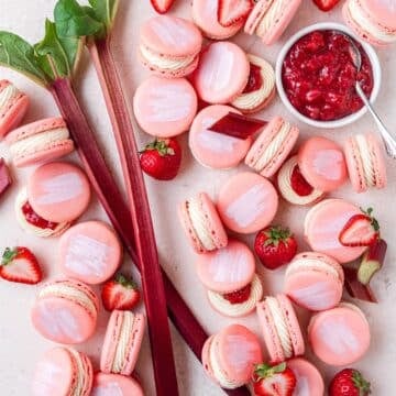 close up of strawberry rhubarb macarons with vanilla bean buttercream and homemade strawberry rhubarb jam.