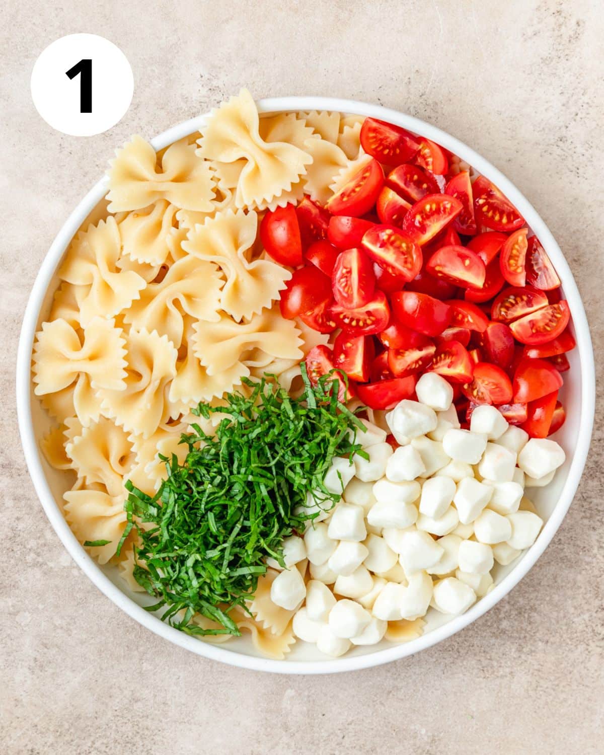 ingredients for caprese pasta salad in bowl. 