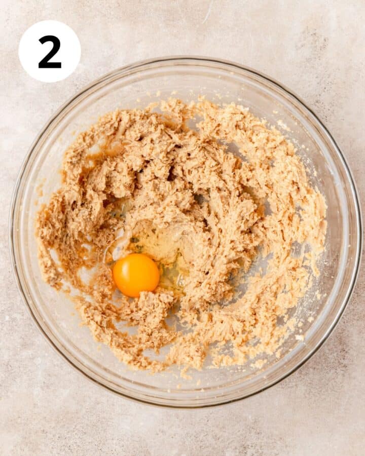 adding egg to cookie dough.