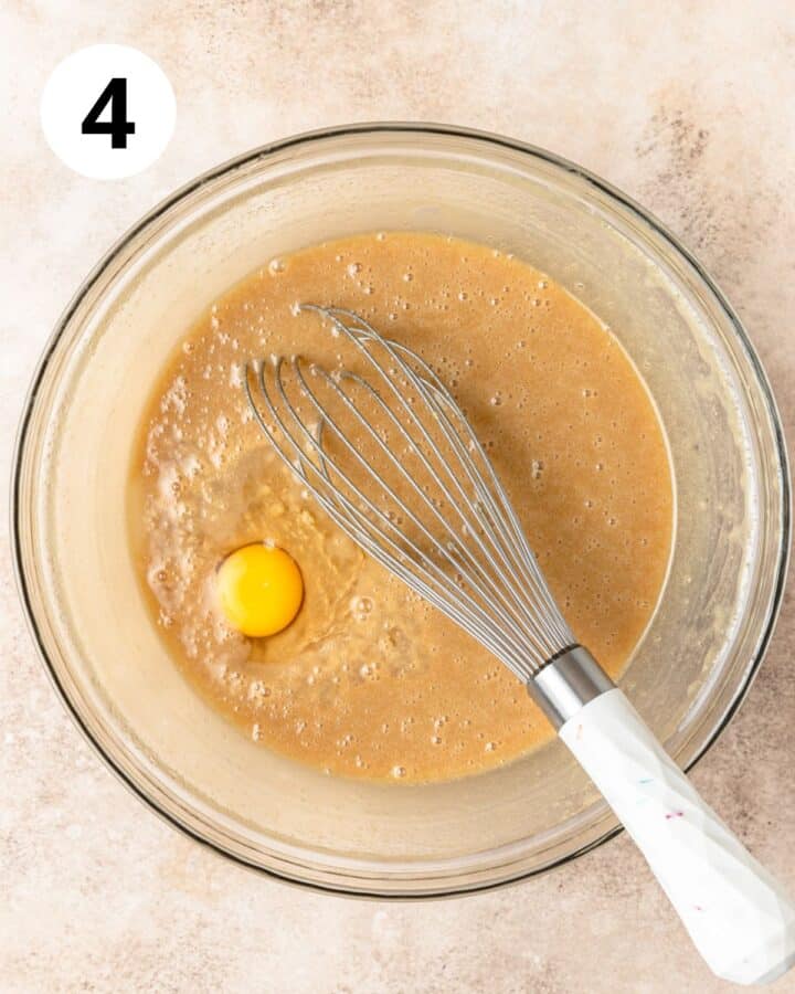 whisking eggs into batter one at a time.