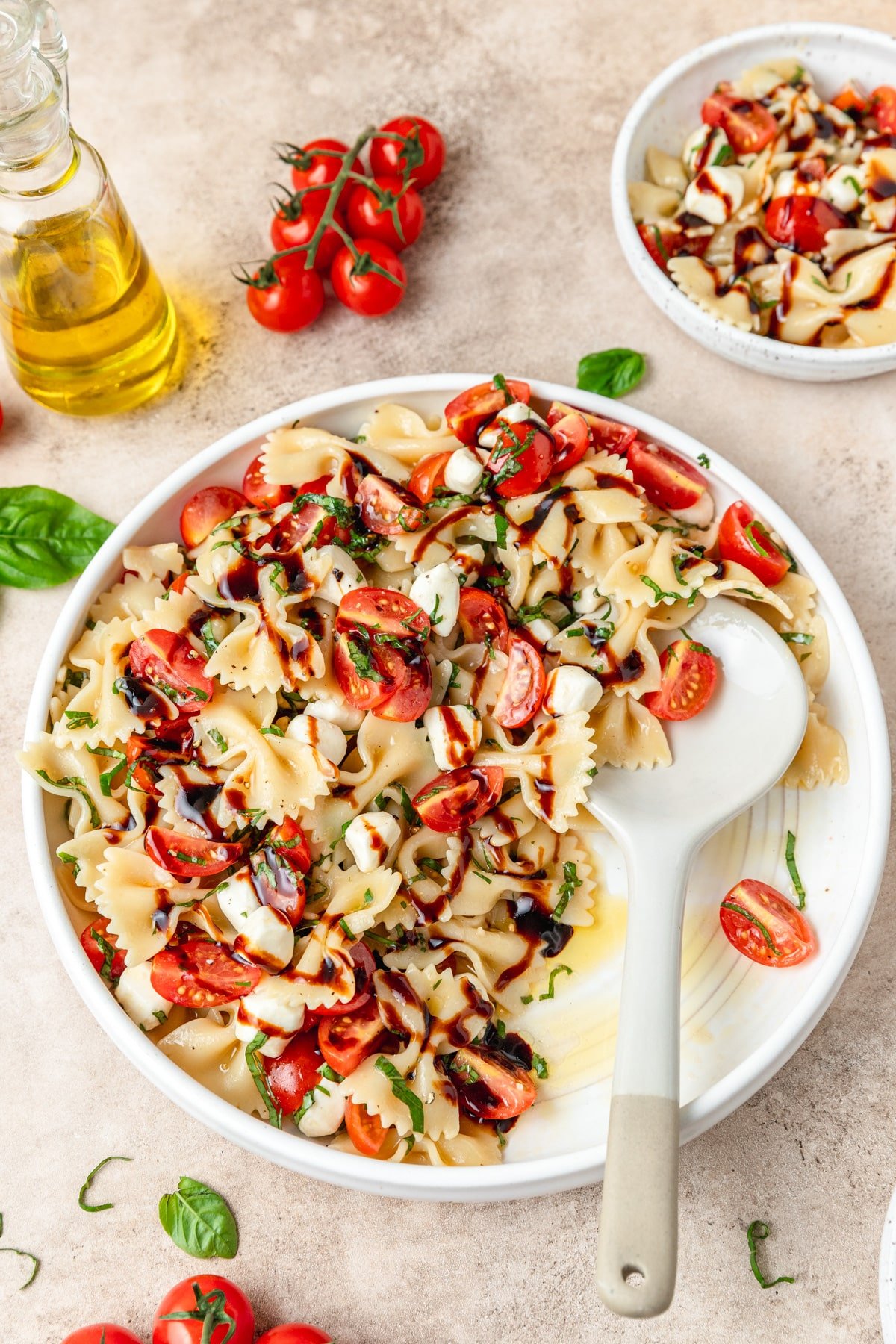caprese pasta salad topped with balsamic glaze.