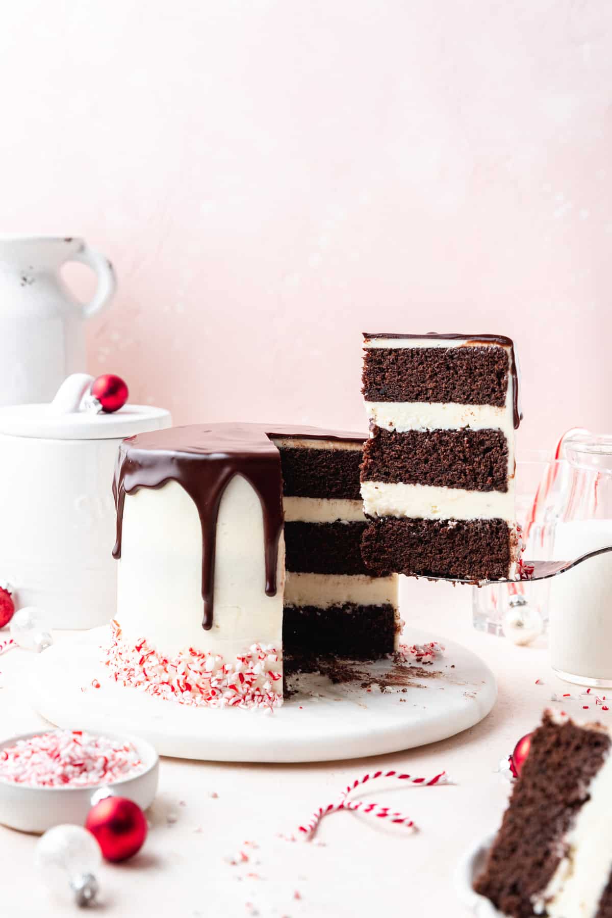 slice taken out of chocolate peppermint layer cake with chocolate ganache.
