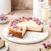eggnog cheesecake with gingersnap cookie crust and topped with sugared cranberries and rosemary.