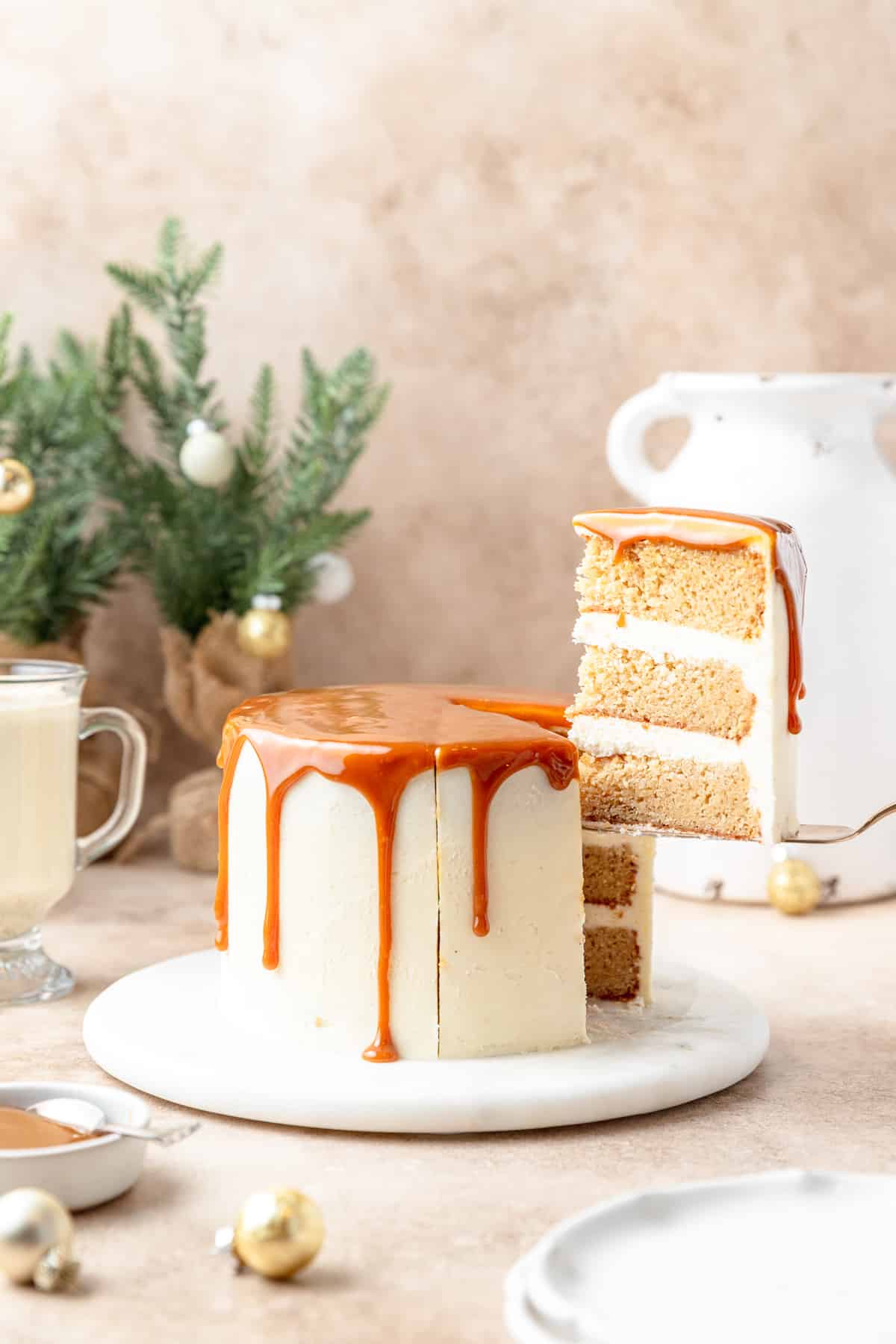 slice of eggnog layer cake topped with salted caramel. 