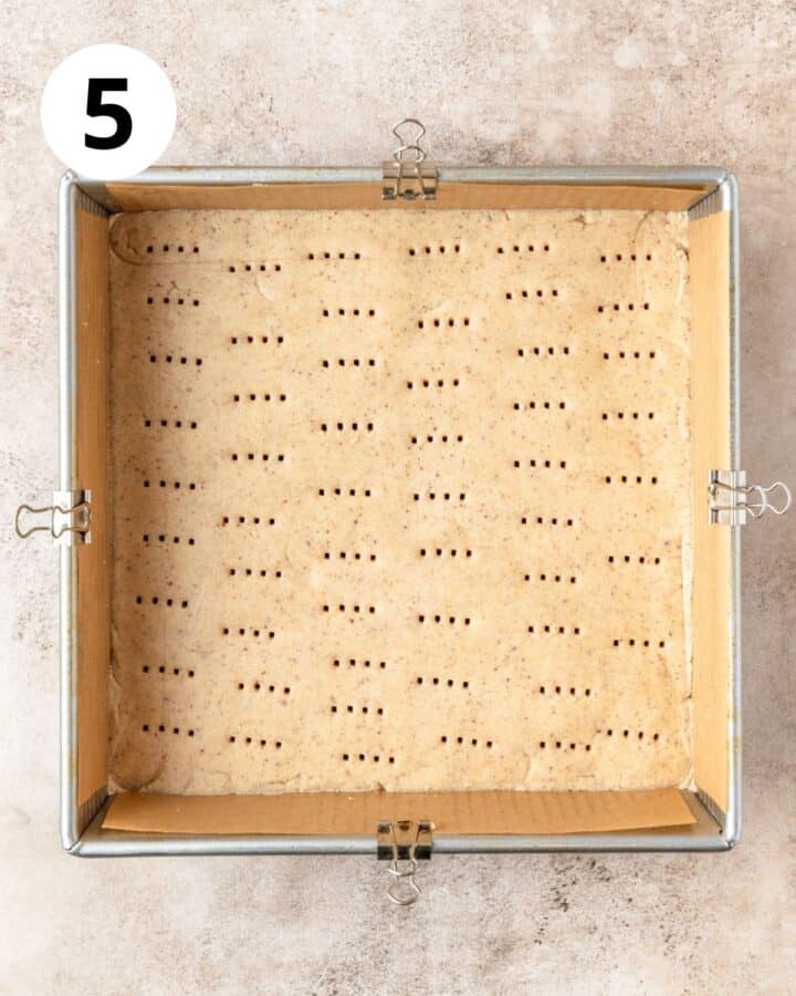 pressing crust dough into square pan.