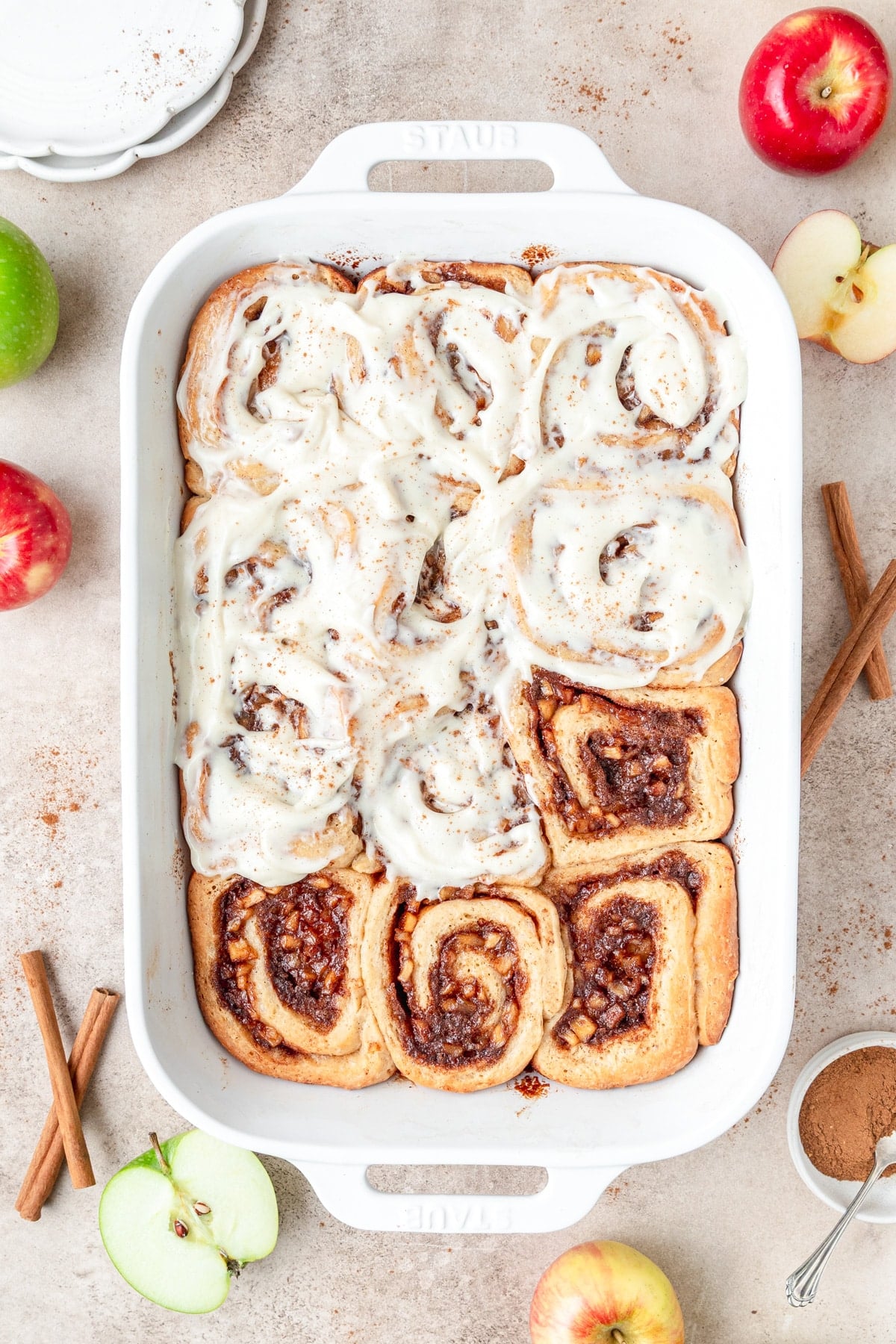 topping apple cinnamon rolls with cream cheese frosting.