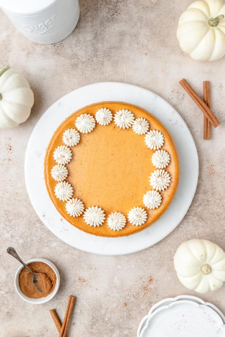 pumpkin cheesecake topped with dollops of whipped cream.