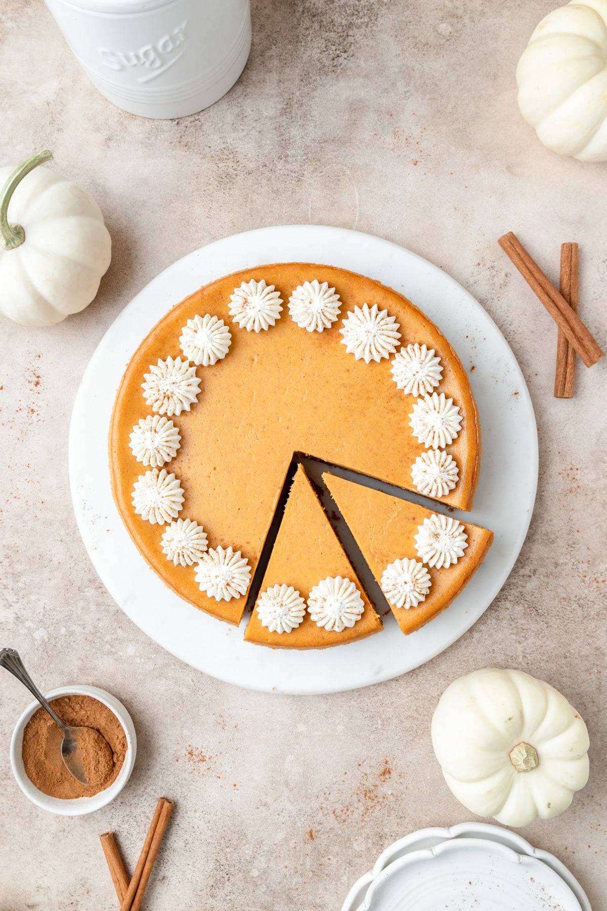 pumpkin cheesecake with whipped cream cut into slices.
